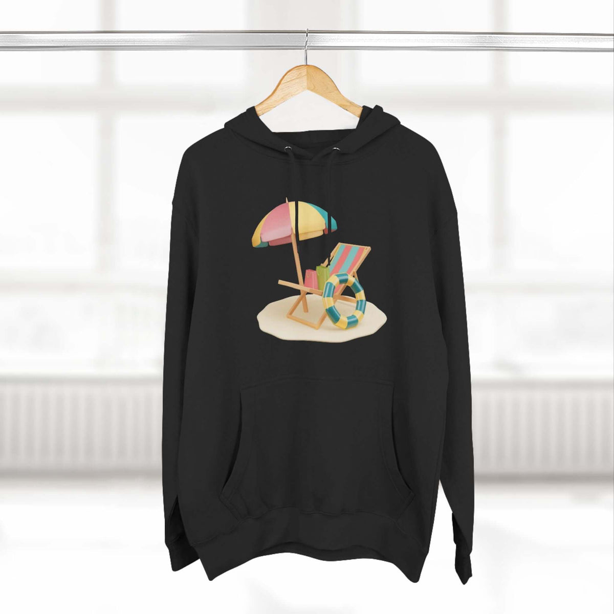 Black hoodie featuring a vibrant beach scene with an umbrella and lounge chair, perfect for a relaxed, stylish look.