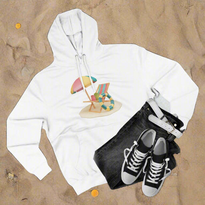 Sunny Resort Hoodie displayed on sandy beach with casual outfit, featuring beach chair and umbrella graphic.