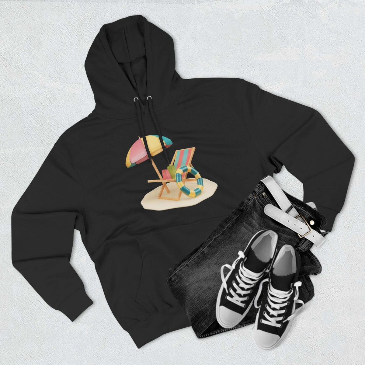 Black Sunny Resort Hoodie featuring a beach chair and umbrella design, paired with casual sneakers and denim.
