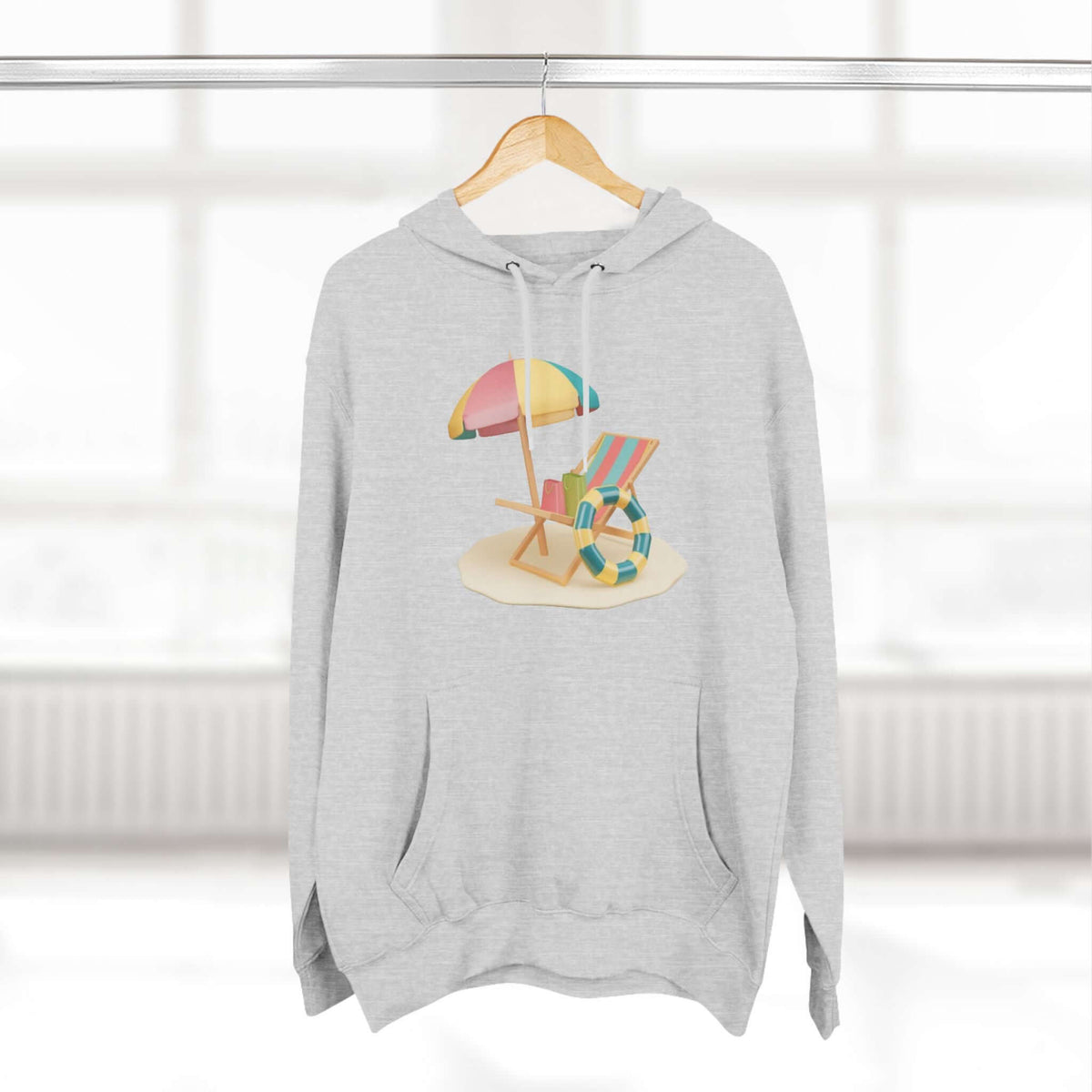 Cozy gray hoodie featuring a beach scene with a colorful umbrella and chair, perfect for relaxed beach vibes.